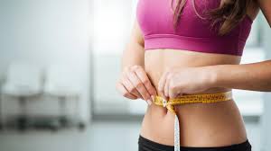 mujer midiendo su cintura con cinta metrica
