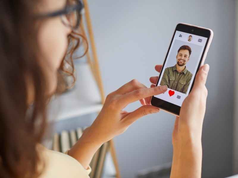 Mujer revisando el perfil de un hombre en una app de citas mientras piensa cómo hablar de salud sexual y VIH.