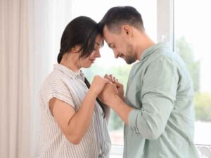Pareja unida en un gesto íntimo y emocional, reflejando el proceso de comprensión mutua al abordar cómo hablar con tu pareja sobre el VIH.